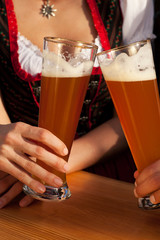 Paar in Tracht stößt mit Weißbier an