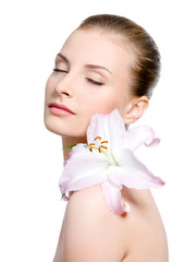 Woman with flower on a shoulder with closed eyes
