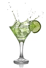Gordijnen Groene alcoholcocktail met splash en groene limoen © artjazz