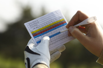 Écrire le handicap au golf avec un gant.