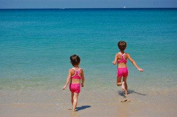 Fototapeta na wymiar Two little girls running to the sea