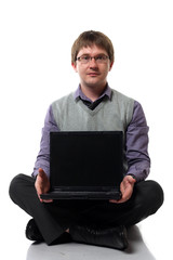 Young manager with laptop sitting on the floor isolated on white