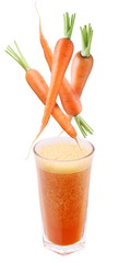 carrot falling into a glass of fresh juice