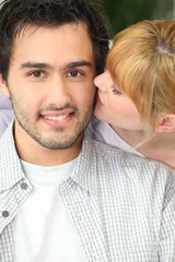 Jeune femme embrassant jeune homme sur la joue