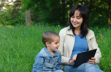 Mother and son with laptop outdoors
