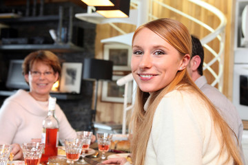Portrait d'une jeune femme déjeunant en famille