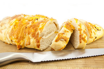 Cheese and Onion Bread on a wooden cutting board with a Knife
