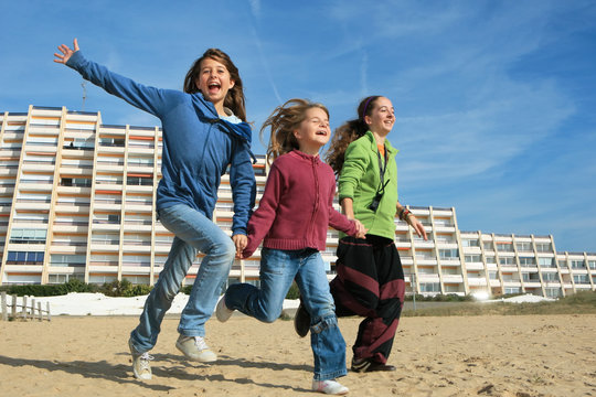 Trois enfants courant sur la plage