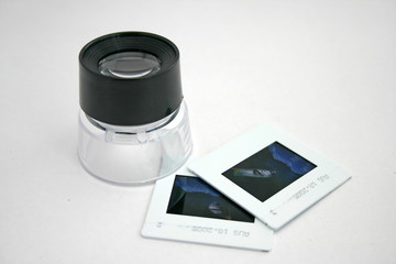 A photographic lupe and two slide film.