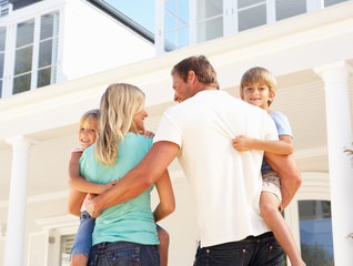 Young Family Standing Outside Dream Home