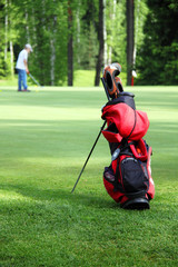 Obraz premium Bag with golf clubs on the golf field