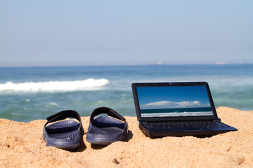 laptop and sandals on the beach