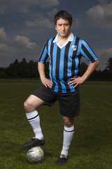 junger dunkelhaariger Mann posiert mit Fussball © spectare