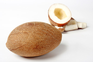 Unshelled coconut on white background with some pieces of nut