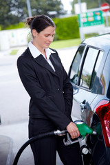 business woman filling car at gas station