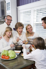 Fototapeta na wymiar Trzy pokolenia rodziny w kuchni jedząc obiad