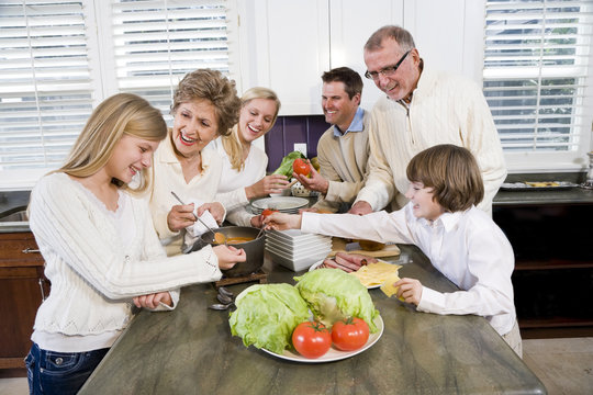 Three generation family in kitchen cooking lunch
