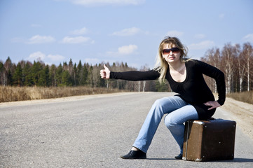 Beautiful country girl hitchhiking on the road