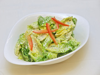 fresh leafy green salad in a bowl isolated on white background