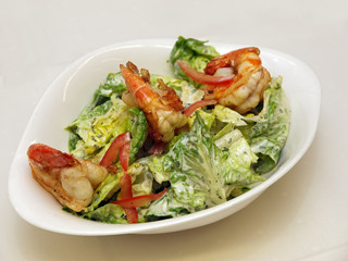 fresh garden salad with grilled prawns on a stylish white bowl