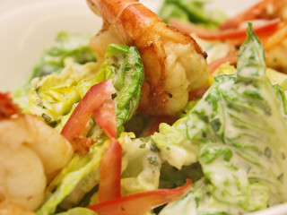 fresh garden salad with grilled prawns on a stylish white bowl