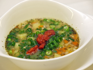 potato soup with sausage slices on a stylish white bowl
