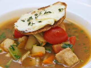 vegetable and meat soup served with crusty bread and butter