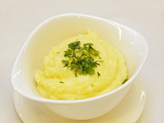 Kartoffelpüree mit frischer Petersilie in einer weißen Schüssel
