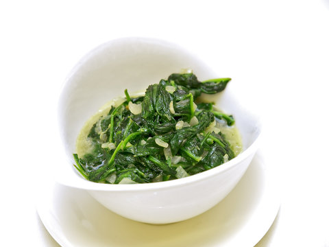 cooked spinach in a white bowl