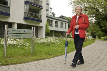 Seniorin vor Altenheim/Pflegeheim