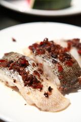 Salmon steak prepared on steam on white plate