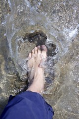 splashing water tourist feet on beach shore