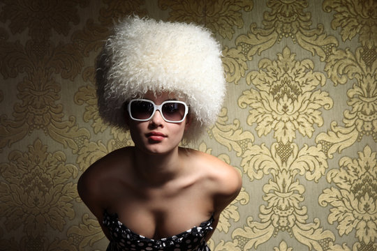 Sexy womanб white fur hat, golden vintage floral background.