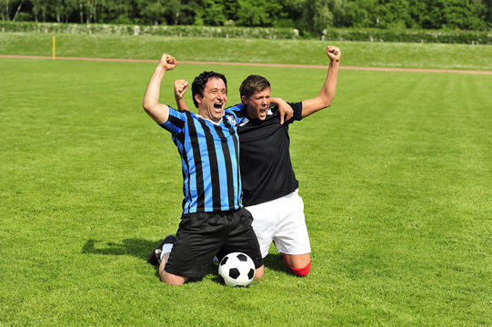 Zwei Fussballspieler jubeln auf dem Fussballplatz