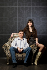 Naklejka premium woman and young man sitting in magnificent ancient armchair