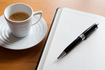Espresso neben Notizbuch, Tagebuch mit Stift
