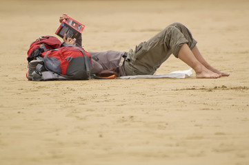 Mujer leyendo en la arena