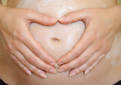 Hands Forming Hearth On Pregnant Belly