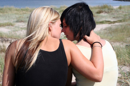 Two women kissing in the sun