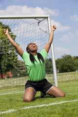 jubelnde Fussballspielerin zeigt beide Daumen hoch