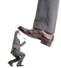 Businessman is kicking by a big foot