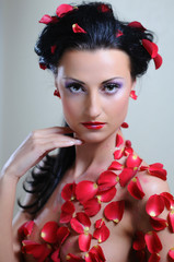 Glamorous portret of young beautiful woman in roses