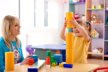 Teacher and preschooler play with building bricks