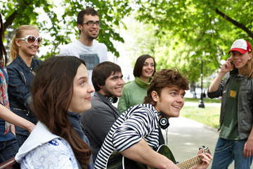 Group of people in city park listen music.
