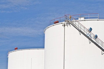 white tanks in tank farm with blue sky