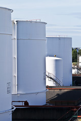 white tanks in tank farm with blue sky