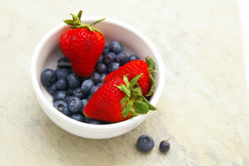 fresh strawberries and blueberries in a bowl
