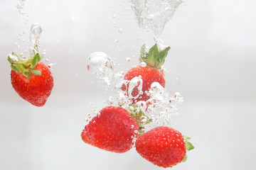 Strawberries falling in water