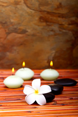 Fototapeta na wymiar Spa kamienie, świece i kwiatów frangipani