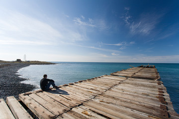 Obraz premium Man sitting at pier